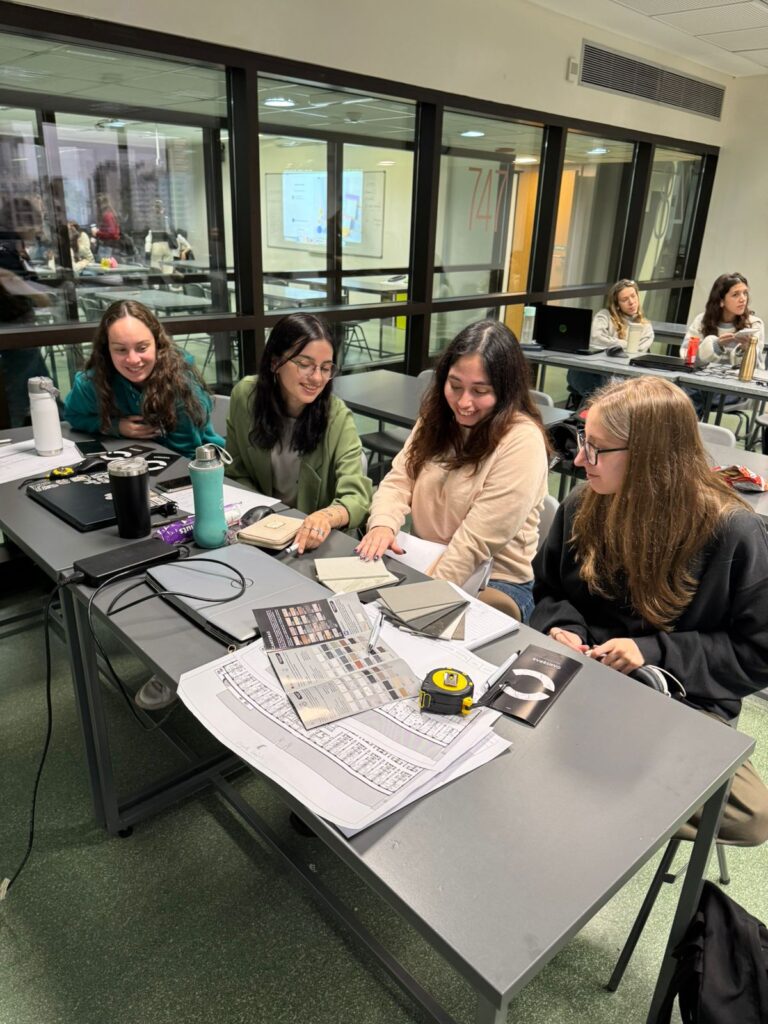 Alumnas de la carrera viendo el catálogo de muestras de materiales.